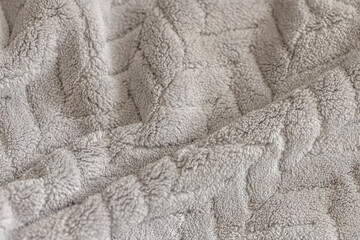 Soft grey fleece fabric with textured surface and natural folds. Shallow depth of field. Cozy neutral textile background ideal for design, home, comfort, and minimal aesthetic concepts. © Mariia