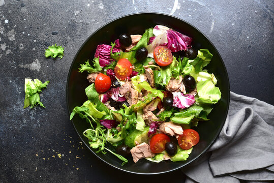 Tuna salad with olives and tomatoes. Top view with copy space.