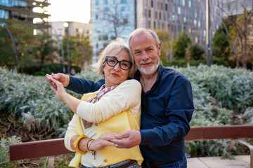 Fototapeta premium Senior couple dancing outdoors demonstrating love and happiness