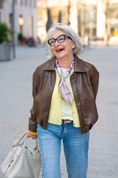 Stylish senior woman laughing on city street