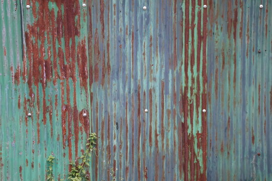 Old zinc surface background. Rusty metal texture. Weathered galvanize texture. Wavy rusty zinc pattern. Rusty tin background