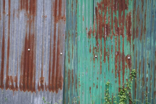 Old zinc surface background. Rusty metal texture. Weathered galvanize texture. Wavy rusty zinc pattern. Rusty tin background