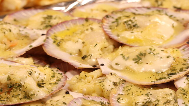 Close Up of Baked Scallops with Melted Cheese and Herb Topping Served in Their Shells at a Street Food Market