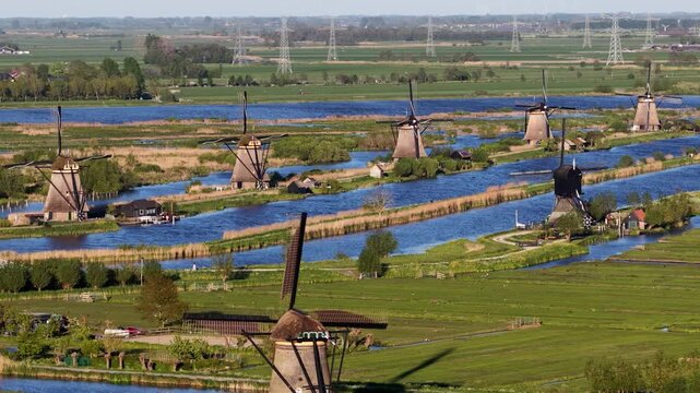 Dutch windmills turning in kinderdijk polder landscape