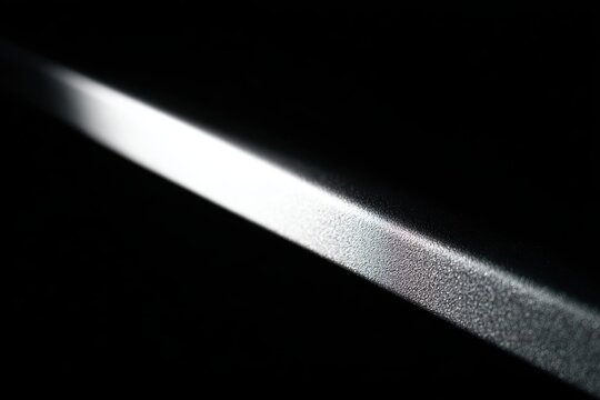 暗闇で光が金属の縁を滑る