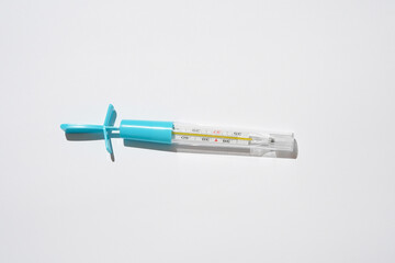 Obraz premium Top view of a mercury thermometer in a turquoise case on a white background with bold shadow