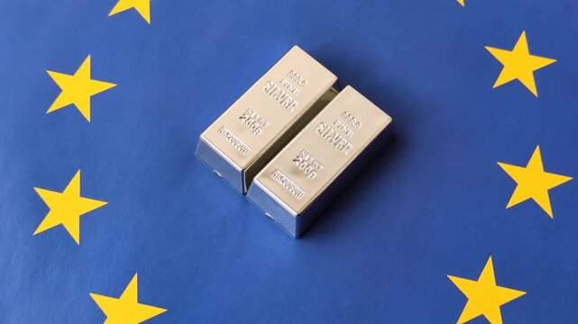 A silver bar, white metal against a backdrop of EU flag, as a concept for the sales market. A silver bar as a background for your design