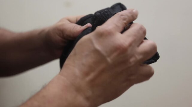 Raw 4K footage of hands opening and closing a strap, showing simple daily action, fastening mechanism, and practical usage in a close-up indoor setting.