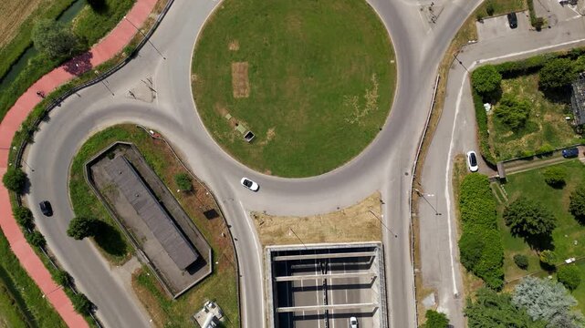 Aerial view of a Road Roundabout: An eye-level aerial view captures the intricate design of a road roundabout, with cars navigating the curves of the infrastructure.