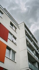 Obraz premium Modern Apartment Building with Colorful Accents and Cloudy Sky in the Background.