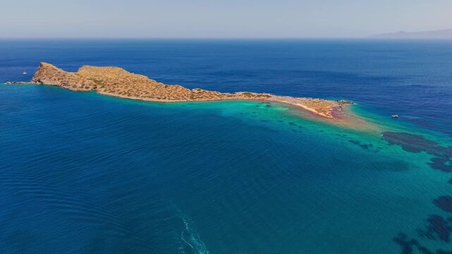 Cinematic orbit over turquoise mediterranean waters and rocky greek coastline