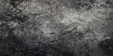 Fototapeta premium A dark aged concrete wall with a rough grunge texture meets a black asphalt surface in this vintage gray stone and cement pattern background