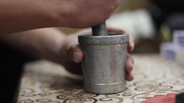Raw 4K footage of masala grinding in a brass Khal Batta also known as Imam Dasta, showing traditional Indian spice preparation and authentic rural kitchen lifestyle.