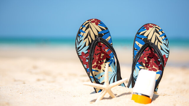 Summer Fashion tourism woman accessories to travel in the beach.  Sandals traveler on the sand beach.  Summer and Trips Concept