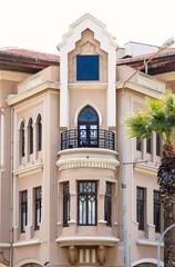 Fototapeta premium Classic architectural facade mockup with a blank blue square sign on a beige stone building wall for logo and branding display.