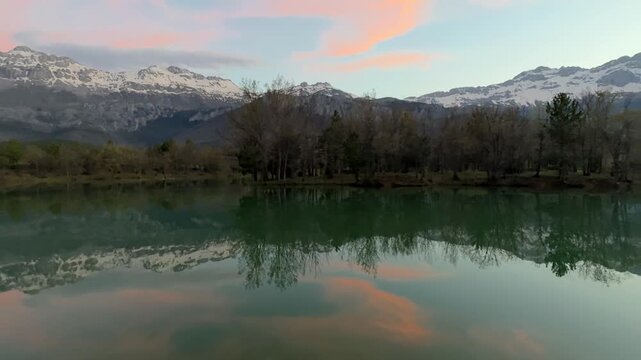 Majestic snow-capped mountains reflected in clear tranquil lake waters