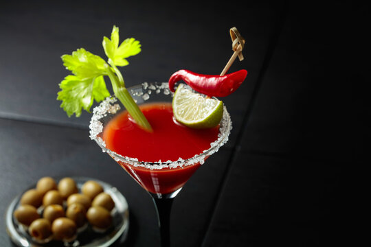 Bloody Mary cocktail with celery, lime, red pepper, and green olives.
