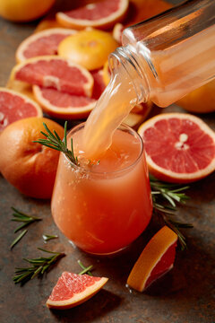 Grapefruit juice is poured into a glass.