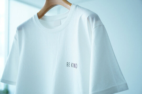 White tshirt with be kind text on a wooden hanger