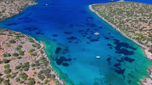 Approaching a beautiful turquoise bay with tourist boats in summer, Crete