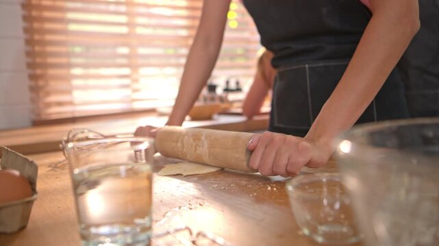 Little girl shaping dough in kitchen with parent nearby, representing learning, creativity, and childhood home cooking experience