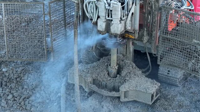 Construction machine works on drilling and pouring concrete at a site in the morning light