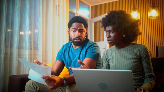 Worried black couple reviewing bills and financial stress at home