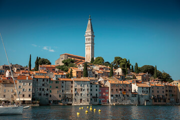 Obraz premium Rovinj, Croatia, 16th August 2025, blue sea, harbour, boats and town with church in the evening light