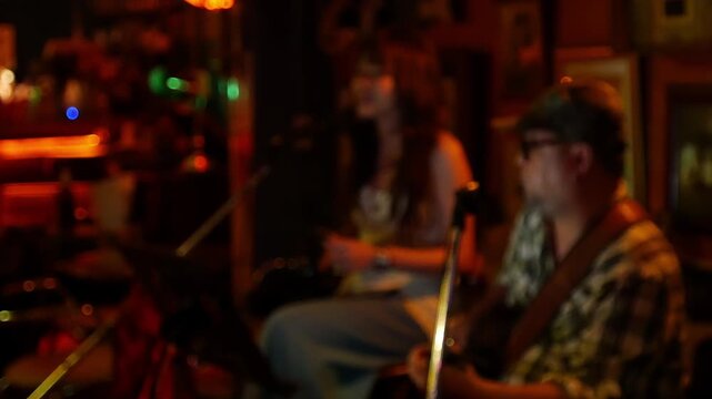 Blurred defocused live music jazz band performance inside cozy vintage bar with warm golden red bokeh ambiance nightlife