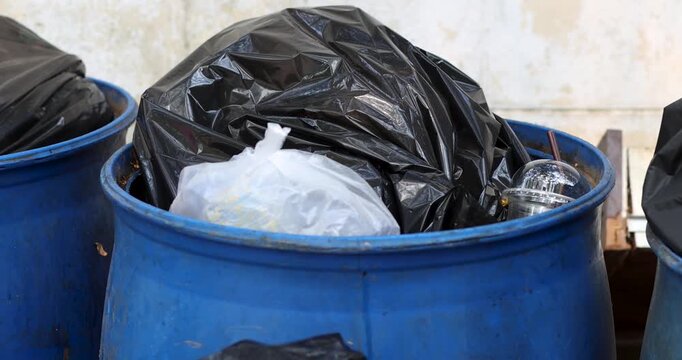 Pile of black garbage bags plastic at a bin, Garbage pile, Plastic waste, Pollution, and urban waste management issues