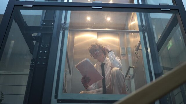 Students preparing for exam in elevator reviewing notes and focusing on study materials during commute to university staying concentrated and mentally ready before important test