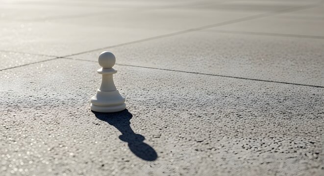 Single white chess pawn on pavement.