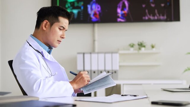 Professional doctor doing paperwork checking medical documents at workplace. Concentrated physician reading medic form analyzing patient diagnosis or report in hospital.