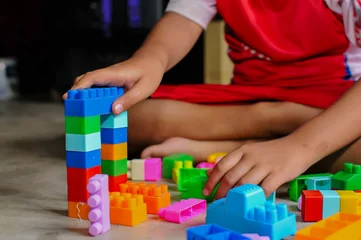 Fotobehang Lego a person playing with colorful, plastic interlocking building blocks  © and