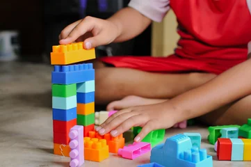 Fototapete Lego child's hands playing with lego at home  © and