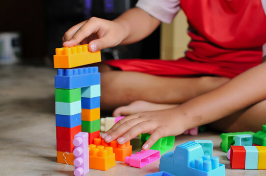 child's hands playing with lego at home