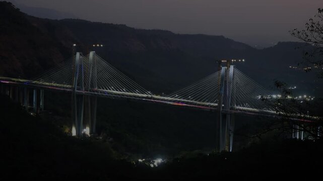 Day to night time-lapse of the Mumbai&ndash;Pune Missing Link bridge on the expressway, capturing the seamless transition from bright daylight to illuminated nightscape.