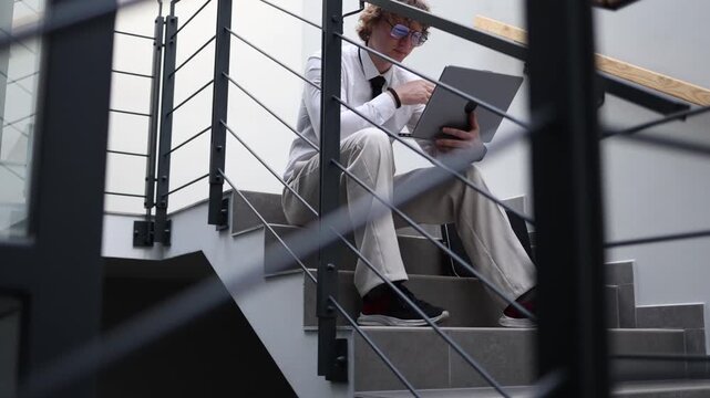 Office worker realizes mistake while working on laptop on stairs feeling stress anxiety and frustration during workday dealing with error consequences and pressure in workplace