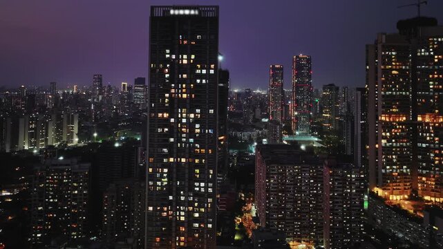 Night timelapse of the Mumbai city skyline, showcasing illuminated skyscrapers, glowing buildings, and continuous traffic movement.