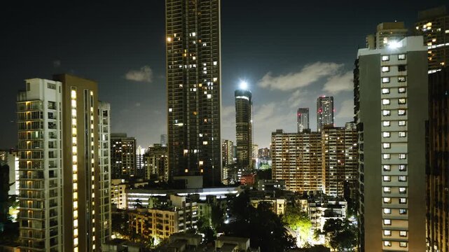 Night timelapse of the Mumbai city skyline, showcasing illuminated skyscrapers, glowing buildings, and continuous traffic movement. The vibrant city lights and dynamic urban atmosphere.