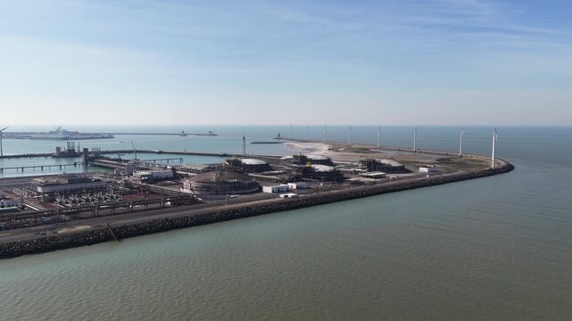 Aerial view of industrial lng terminal and wind turbines at seaport