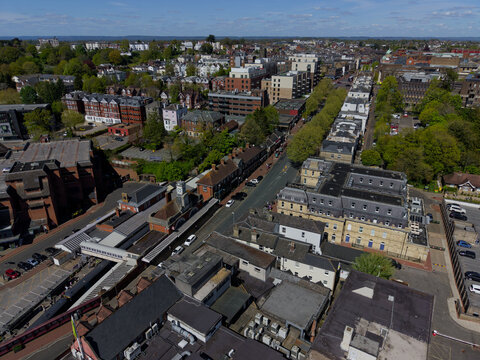 Aerial view of Tunbridge Wells town center with train station. Cars on the street. Residential apartment buildings.
