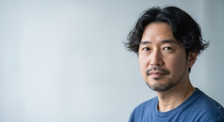Obraz premium Portrait of a thoughtful japanese man with dark wavy hair and a light beard