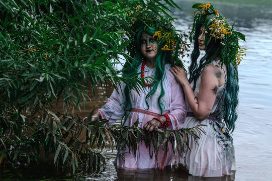 Rusalka in white with a wreath on her head and green hair