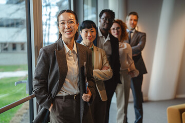 Asian business woman leading diverse professional team at office