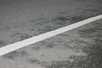 Fototapeta premium Page |12345...74Next black asphalt road with a central white line close up perspective highlighting texture and details of the surface against a dark background