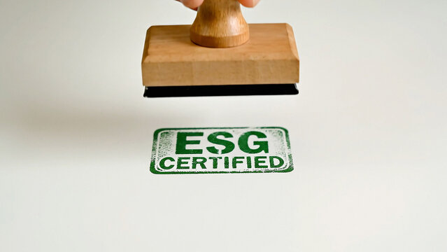 Wooden rubber stamp with green ESG certified imprint on paper