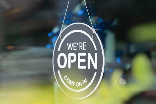 We are open sign hanging on glass shop window, open business concept and customer invitation, retail store, service industry, customer experience and offline business comeback concept