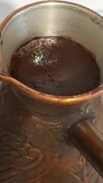 the foam of boiling coffee in a Turkish cezve