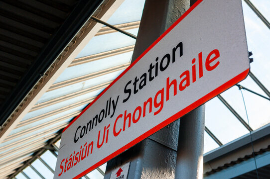 Bilingual station sign for Dublin Connolly railway station displaying the station name in English and Irish on a platform post.